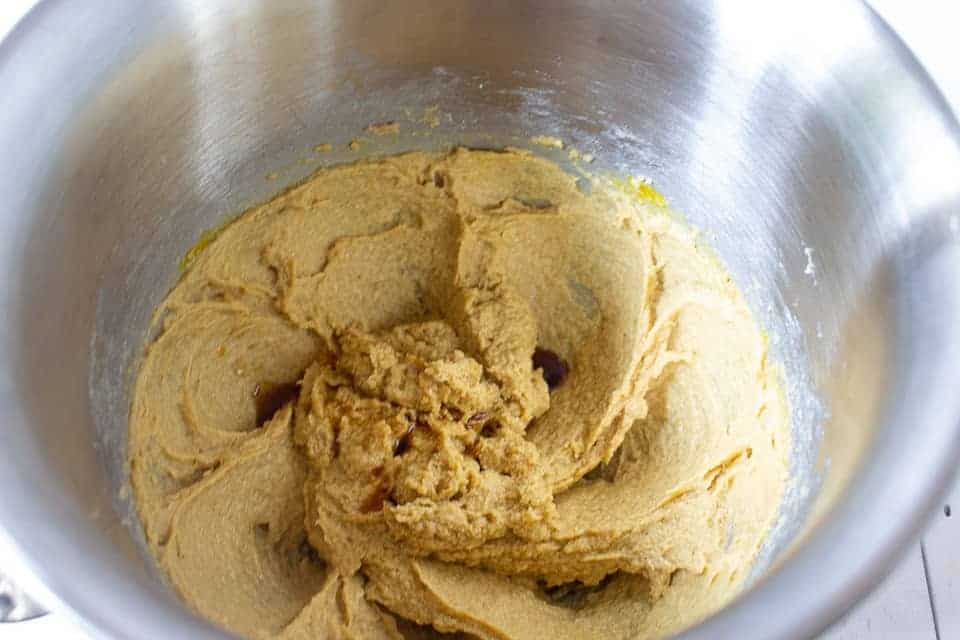 3 Vanilla added to cookie dough in a bowl.