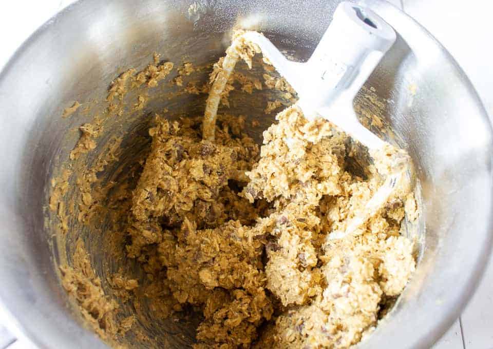 6 Mixed cookie dough in a bowl with a mixing paddle.