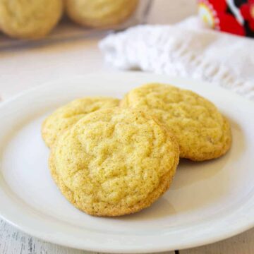 Three sugar cookies arranged on a white plate.