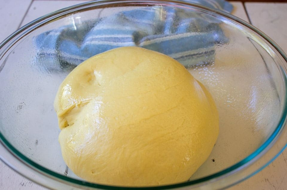 Bread dough in a greased glass bowl.