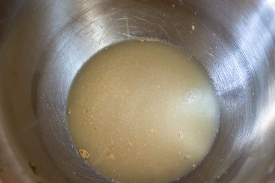 A silver bowl filled with yeast and water.