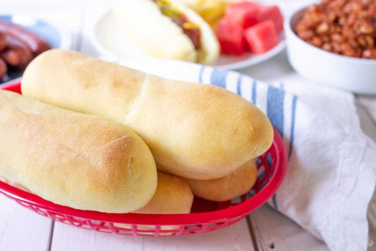 A red basket filled with homemade hot dog buns.