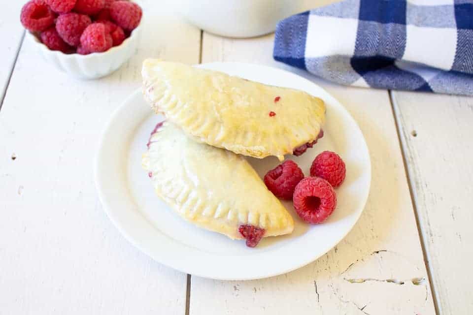 Mini raspberry pies on a white plate. 