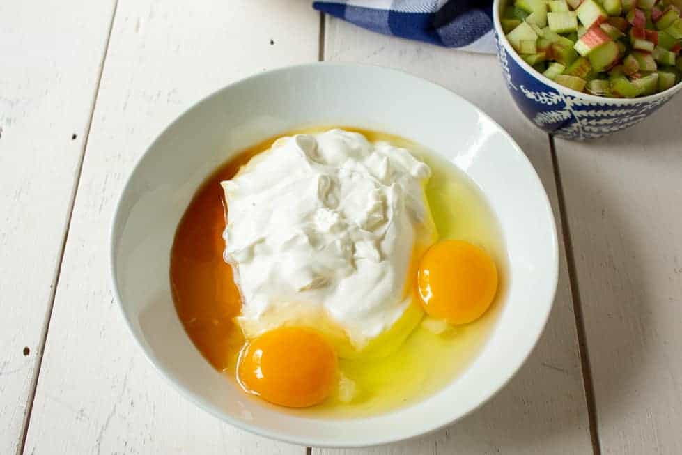 A bowl with sour cream, eggs, butter and vanilla.