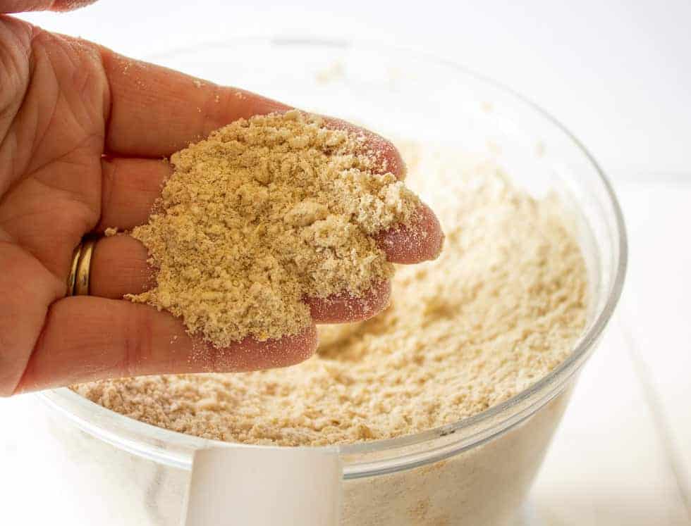 Ground flour, butter and sugar held in one hand.