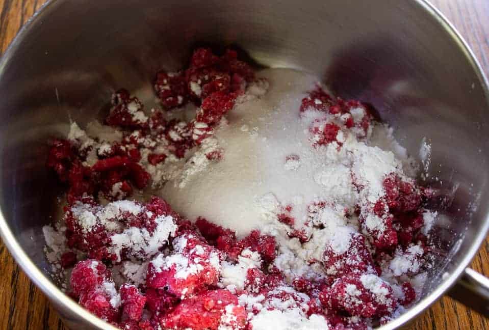 A saucepan filled with raspberries, flour and corn starch.