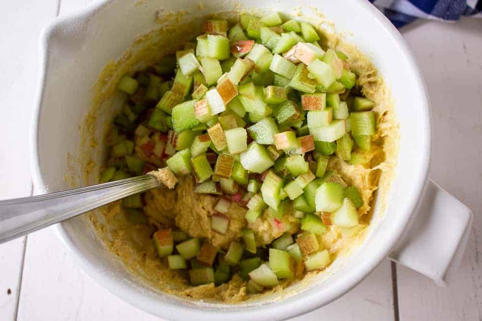 Chopped rhubarb being added to muffin batter.