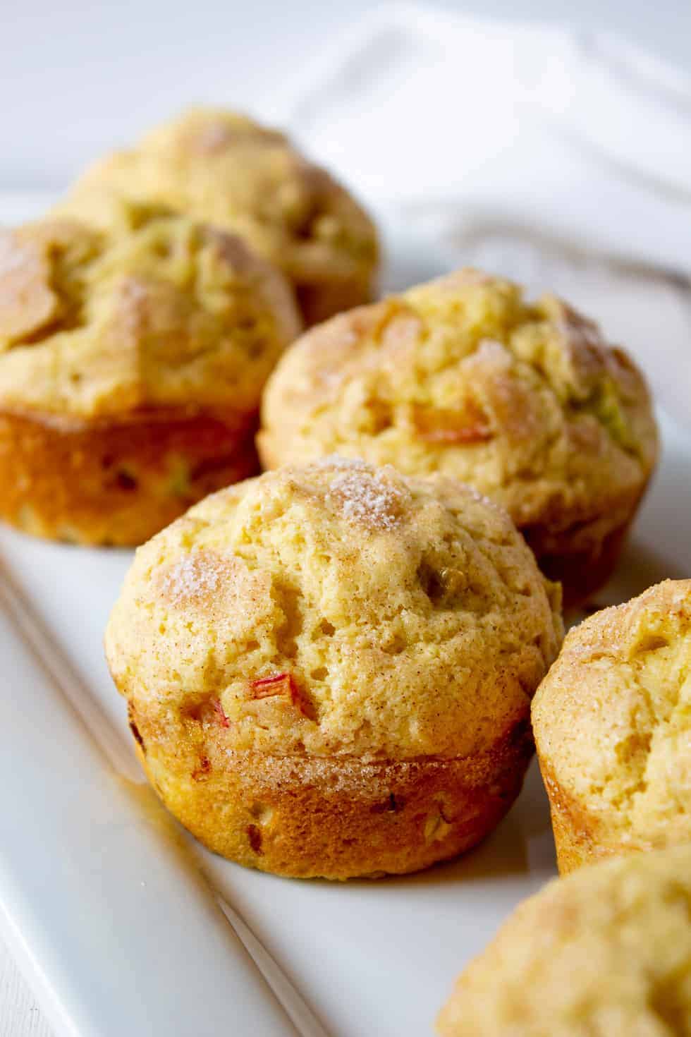 A white platter filled with fresh rhubarb muffins. 