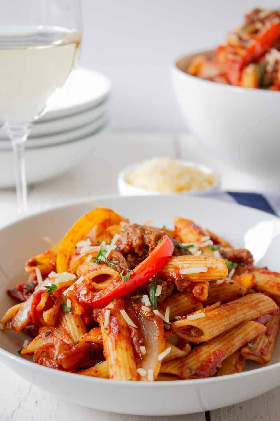 A white bowl filled with sausage pepper pasta.