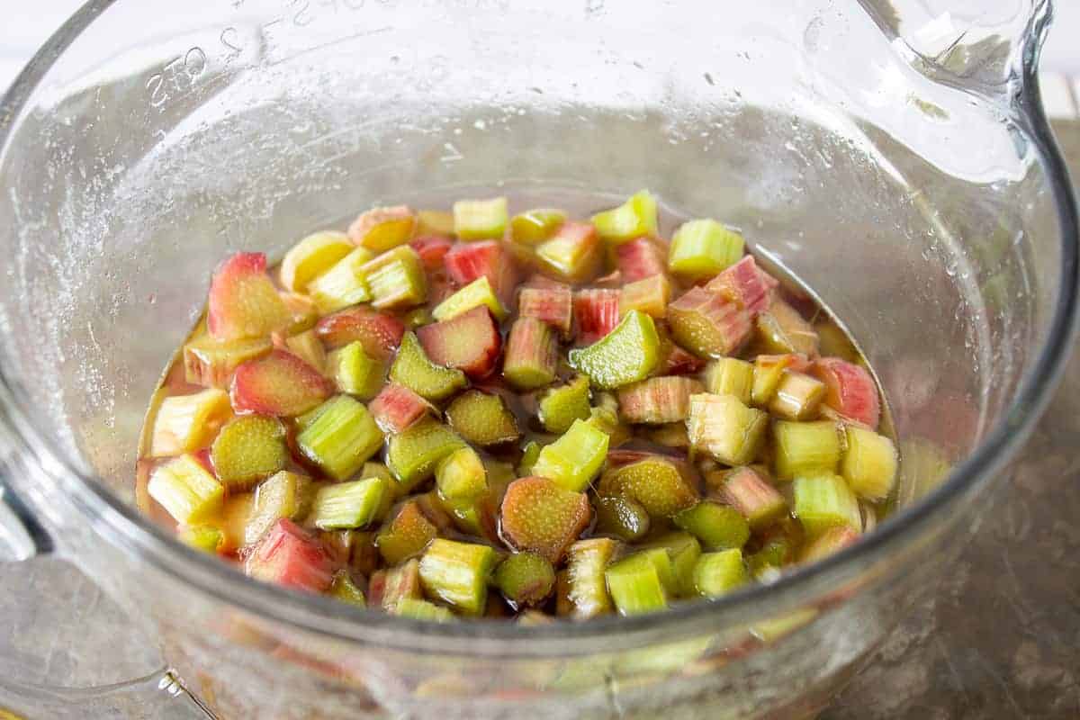 Macerated rhubarb in a bowl filled with liquid.