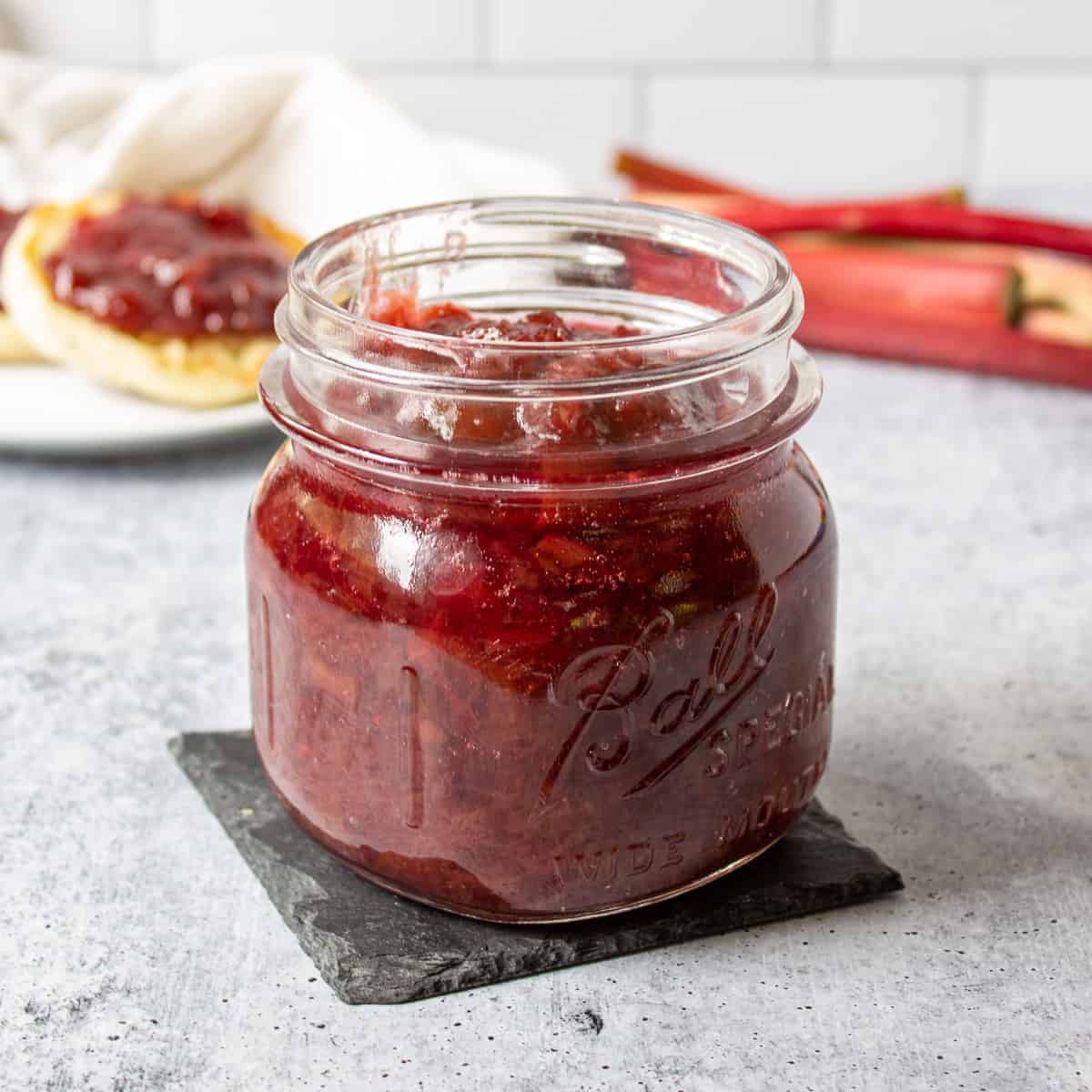 A glass jar filled with homemade rhubarb jam.