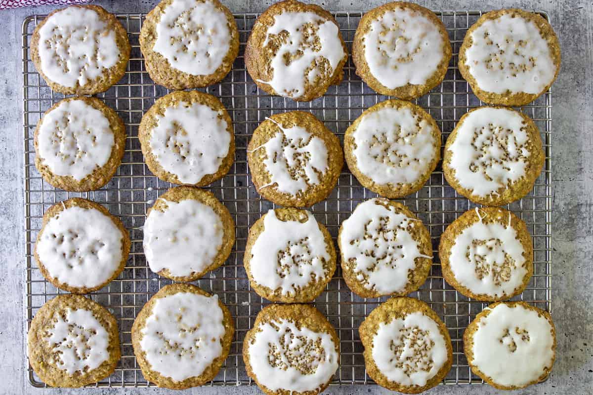 Rows of iced oatmeal cookies on a baking rack.
