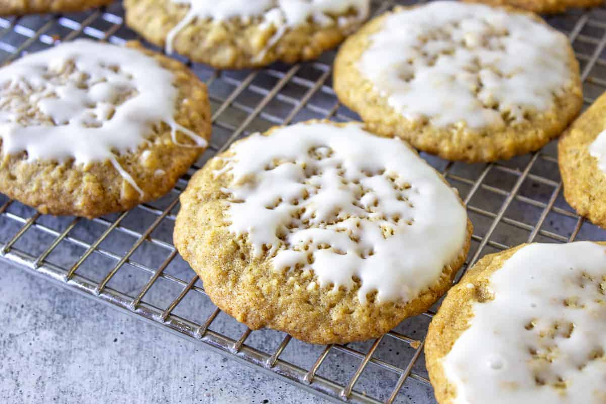 Iced oatmeal cookies on a baking rack.