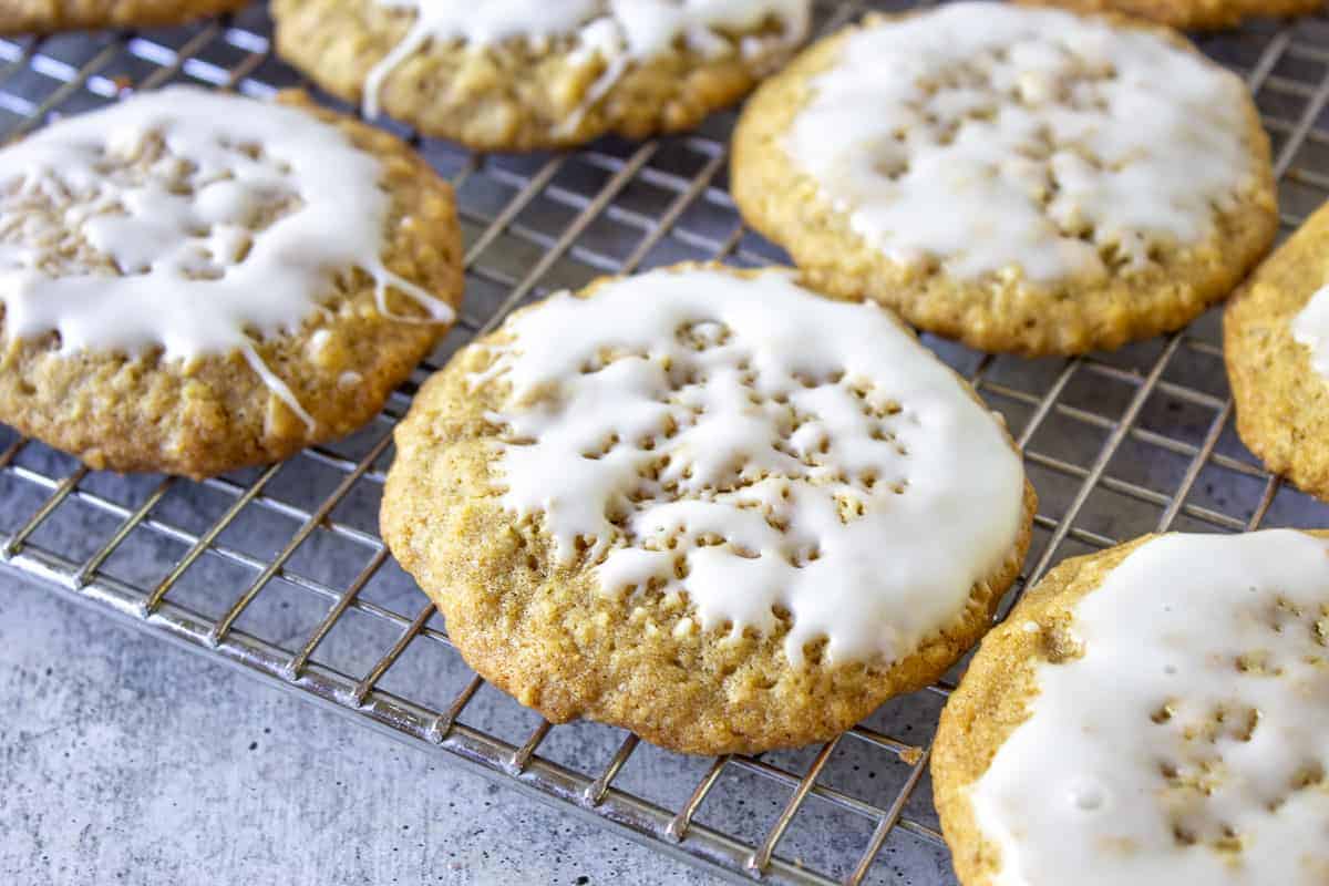 Iced oatmeal cookies on a baking rack.
