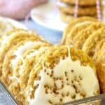 Iced oatmeal cookies arranged in a glass container.