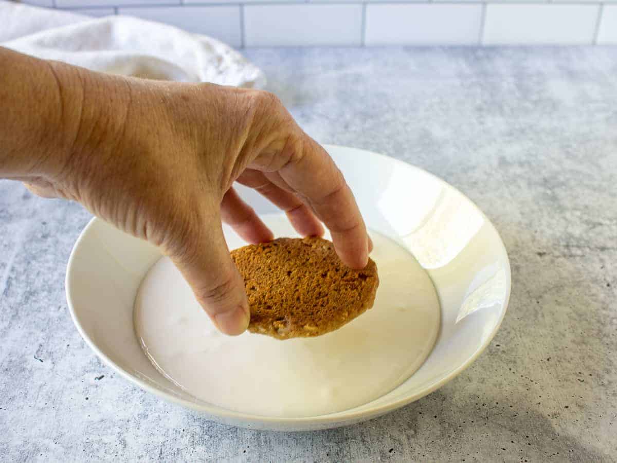 Dipping an oatmeal cookie into icing.