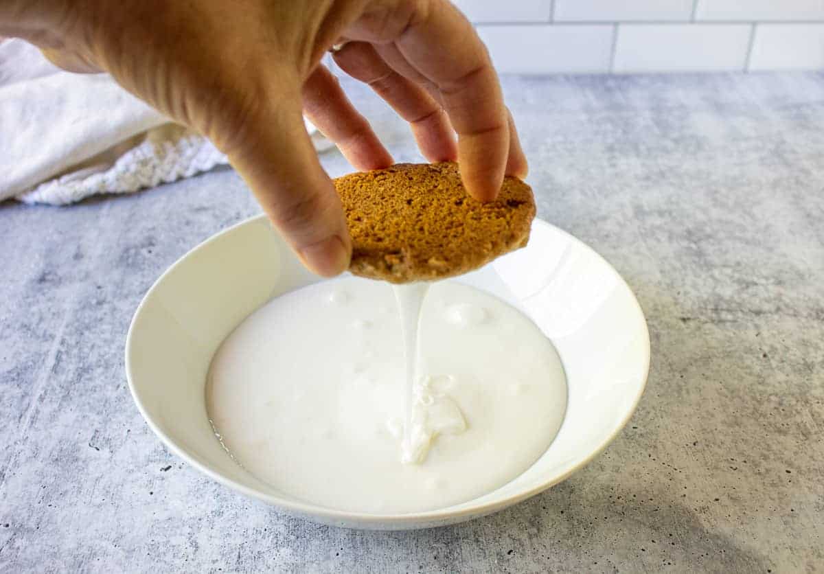 Icing dripping off the bottom of an oatmeal cookie.