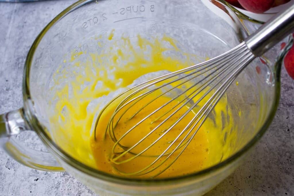 Whipped egg yolks in a glass bowl.