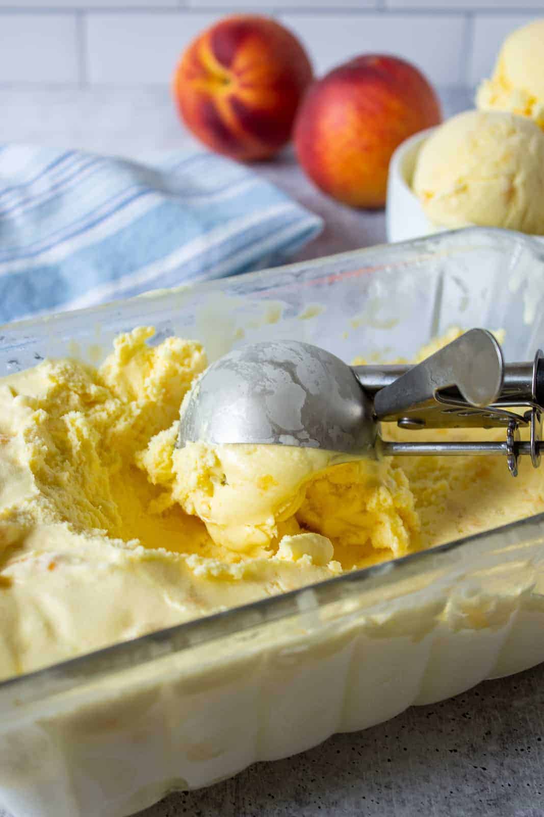 Peach ice cream in a glass loaf pan.