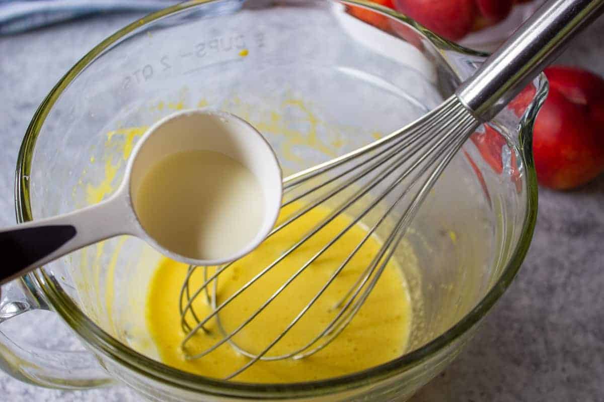 Egg mixture with hot cream being added to mixture.