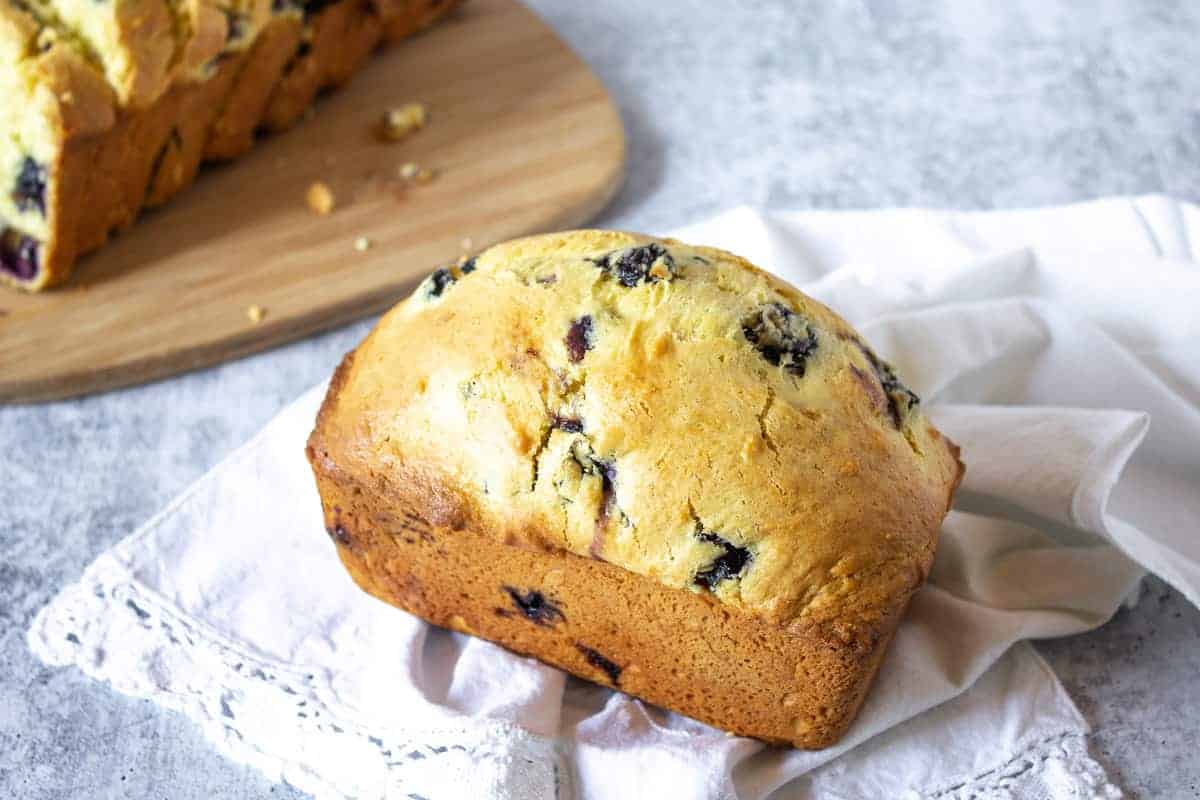 Small loaf of blueberry lemon bread on a white napkin.