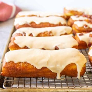Frosted maple bars on a baking rack.