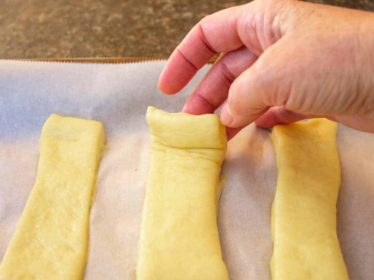 Picking up dough from a baking sheet. 