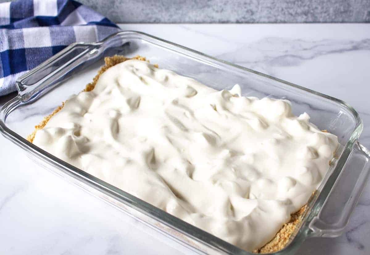 Whipped cream spread over top a cookie crust.