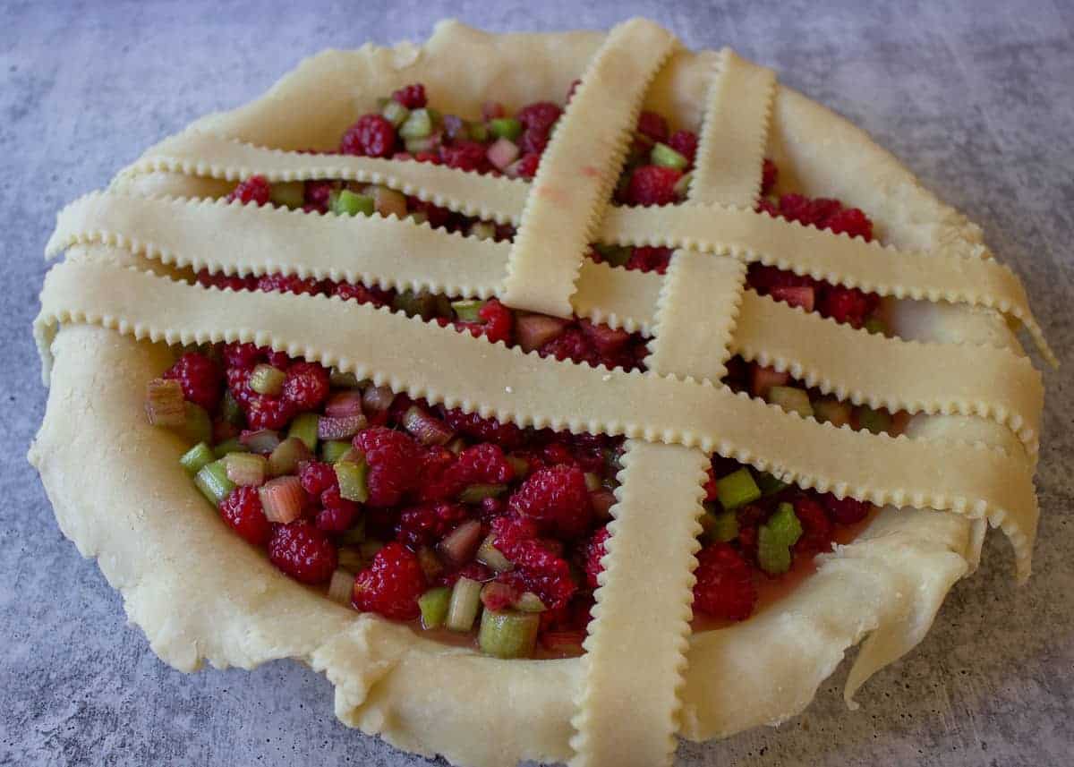 Folding back a lattice strip to create the pattern on top of a pie.