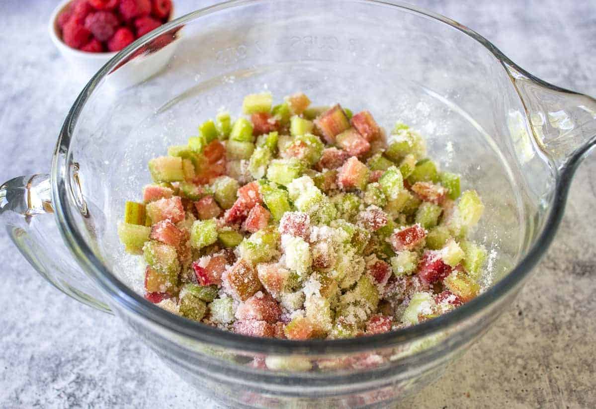 Rhubarb covered with sugar in a glass bowl.