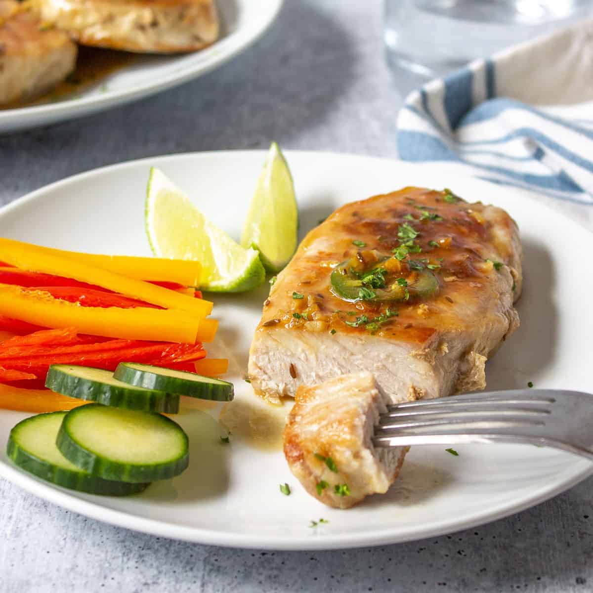 Boneless pork chop topped with a light sauce and jalapeno slices.