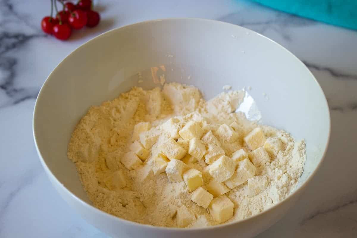 Flour in a bowl with small cubes of butter.