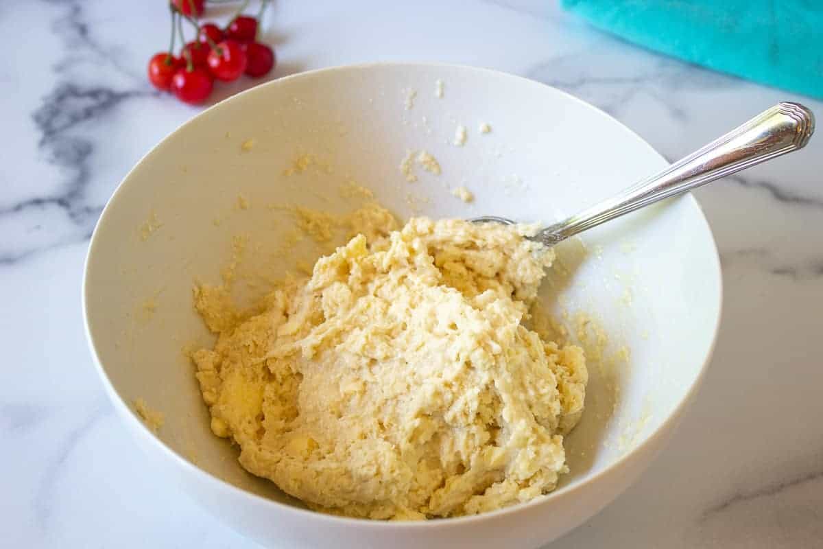 Biscuit dough in a white bowl.