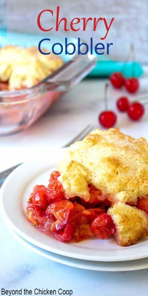 Cherry cobbler with a biscuit topping on a white plate.
