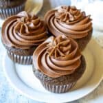 Three chocolate cupcakes topped with swirled chocolate buttercream.