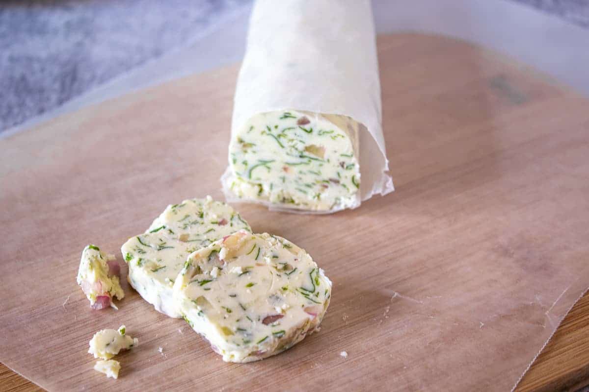 Slices of butter with herbs and shallots. 