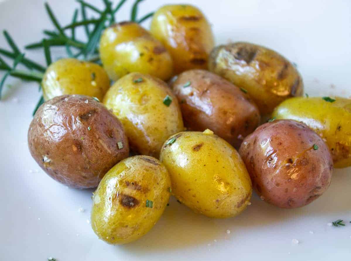 Grilled baby potatoes on a white plate. 
