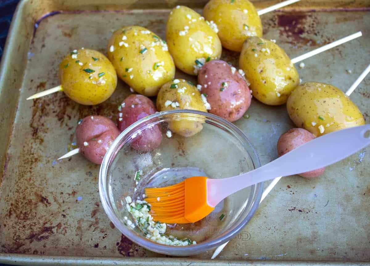 Skewered potatoes covered with a coating of oil and skewered on a wooden skewer.