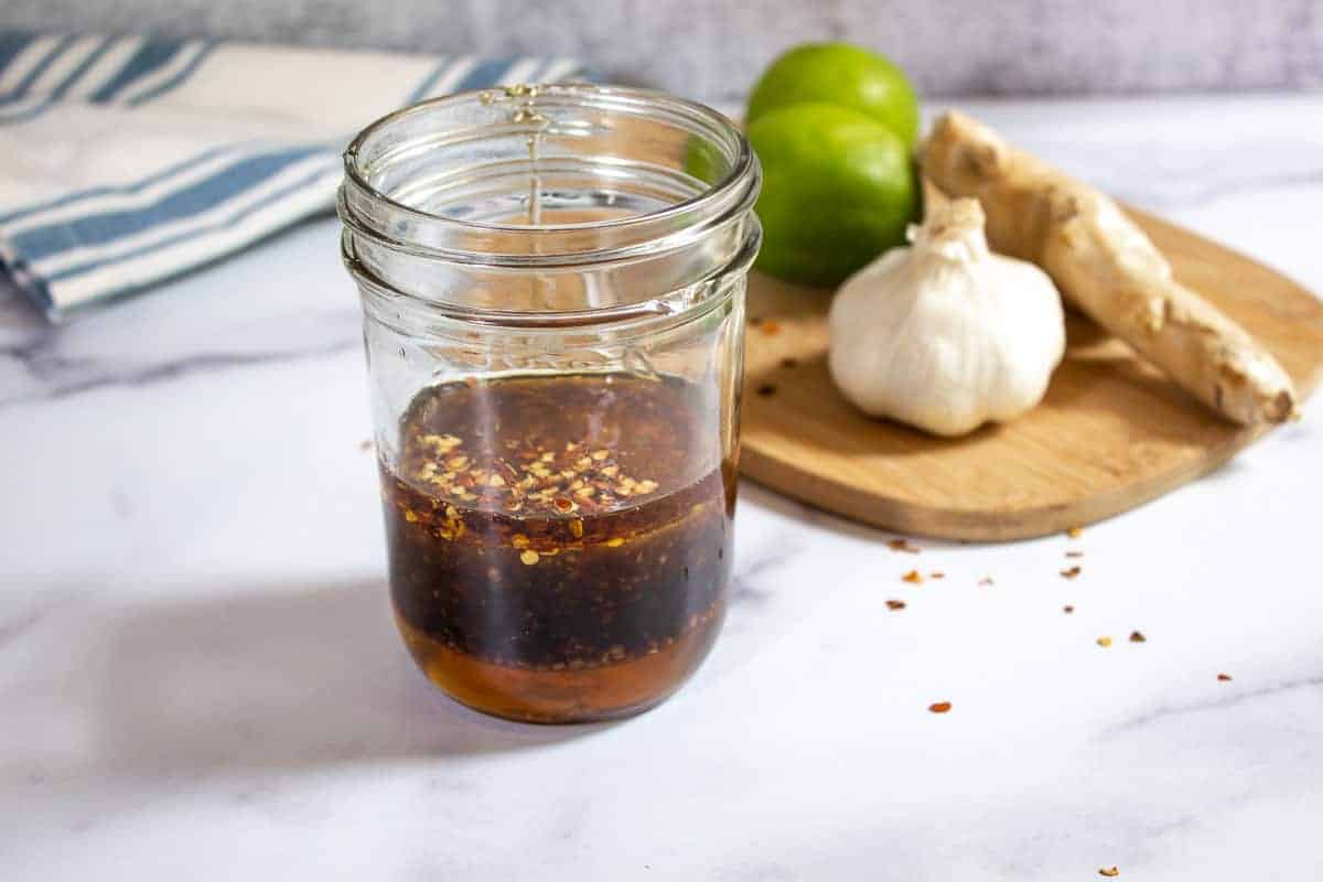 A jar filled with honey lemon marinade.