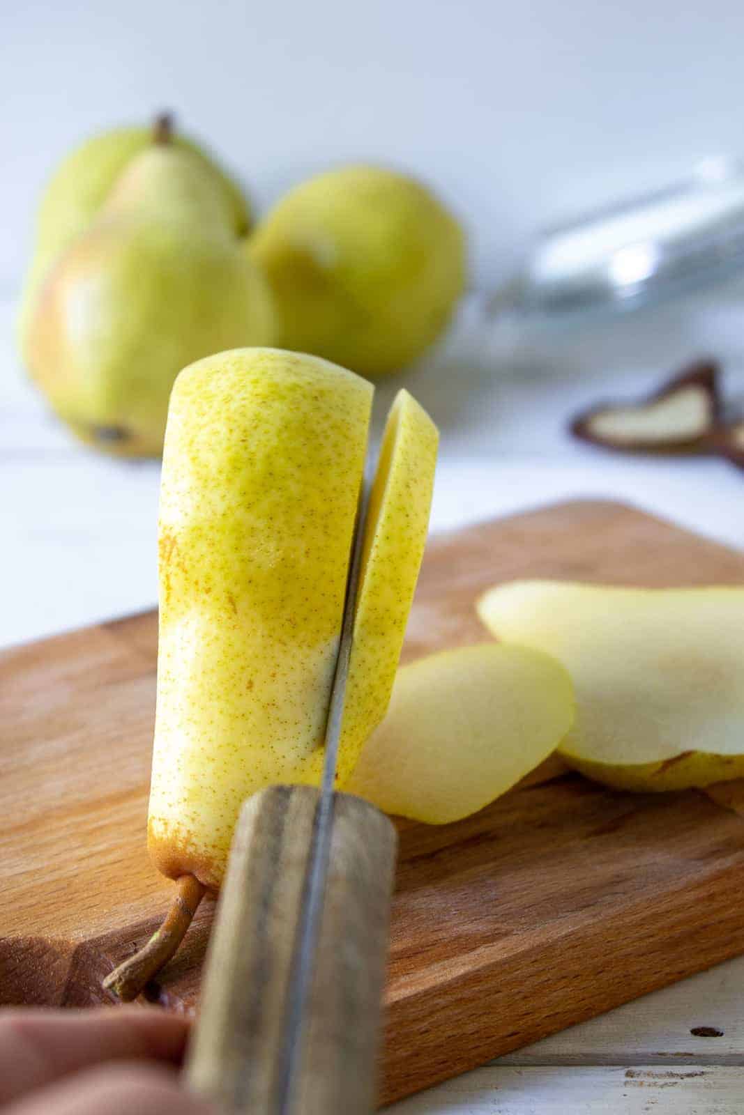 A pear being sliced into long strips. 