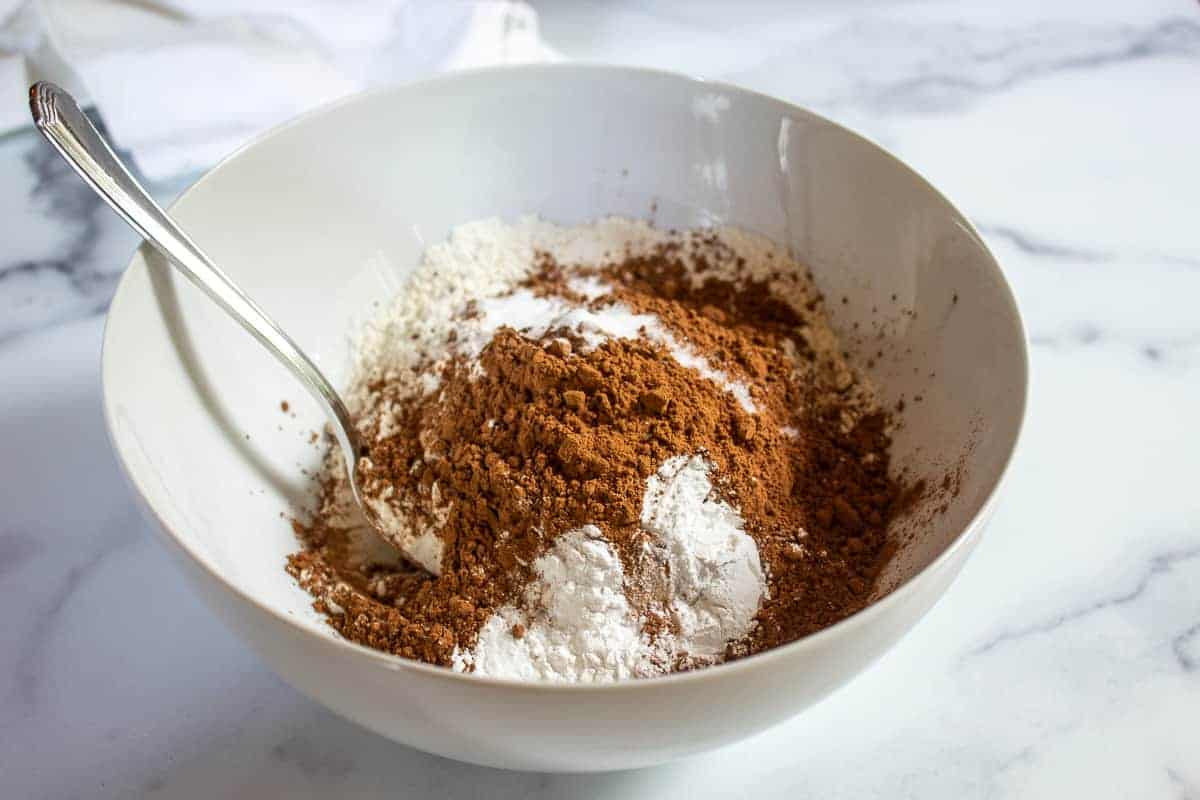 Flour and cocoa powder in a white bowl.