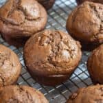Chocolate muffins on a baking rack.