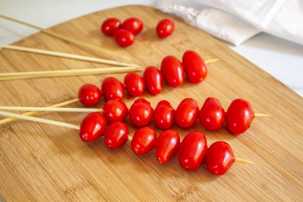 Cherry tomatoes skewered on wooden sticks.