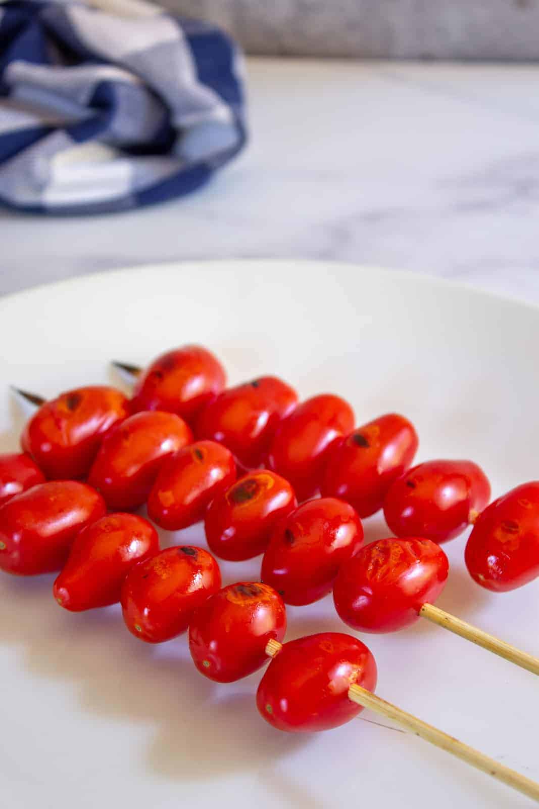 Cherry tomatoes on a wooden skewer.