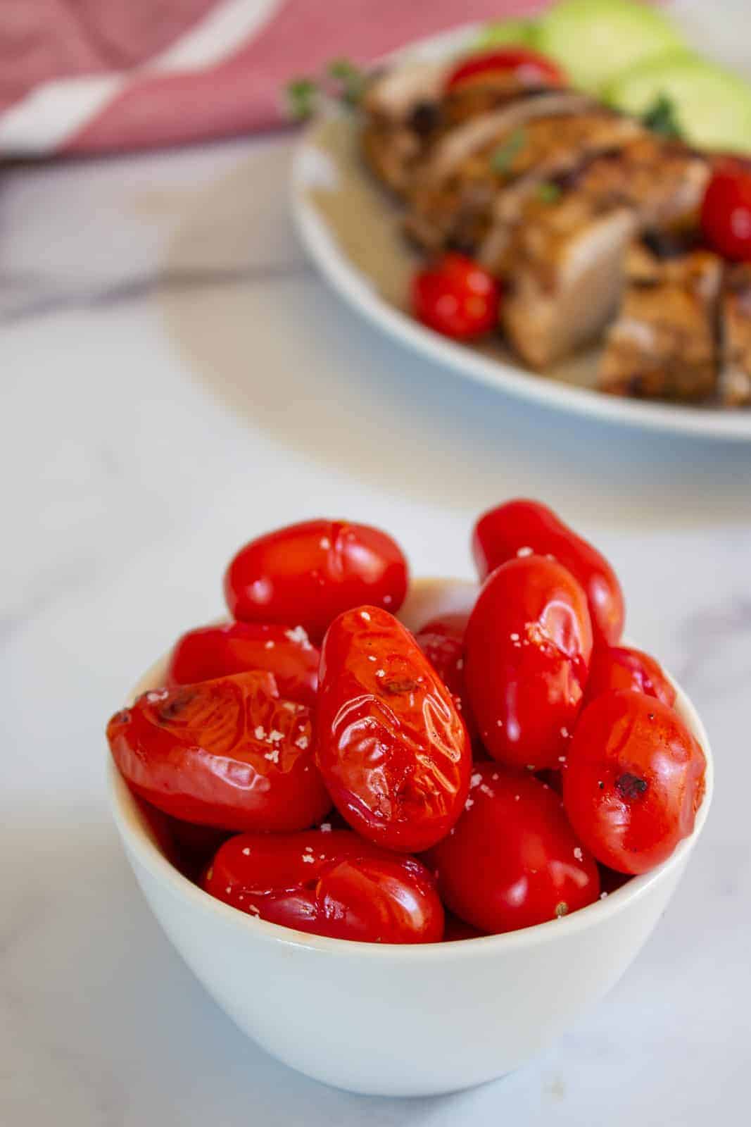 Grilled tomatoes in a small white bowl.