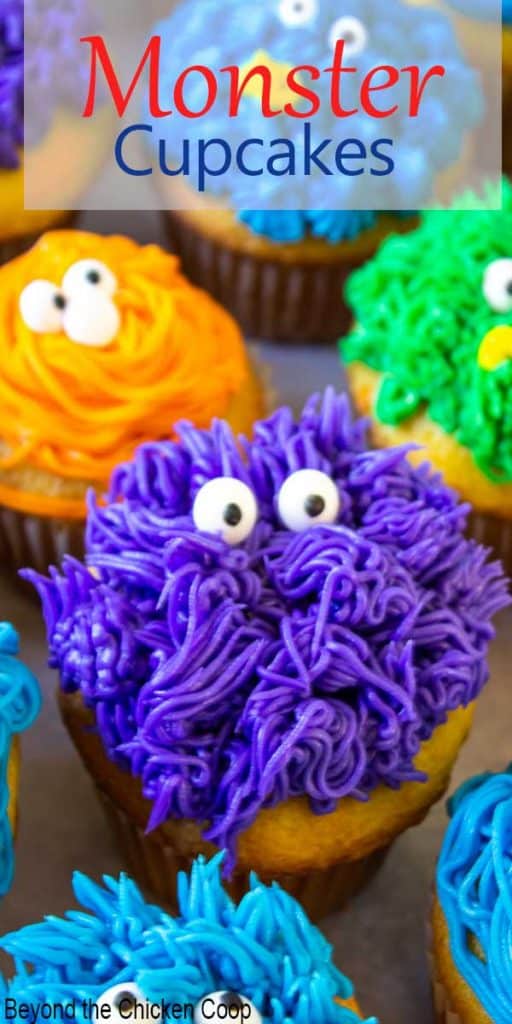 Purple, orange and blue frosted cupcakes with candy eyes.