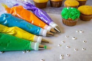 Colorful bags of frosting with different cake decorating tips.