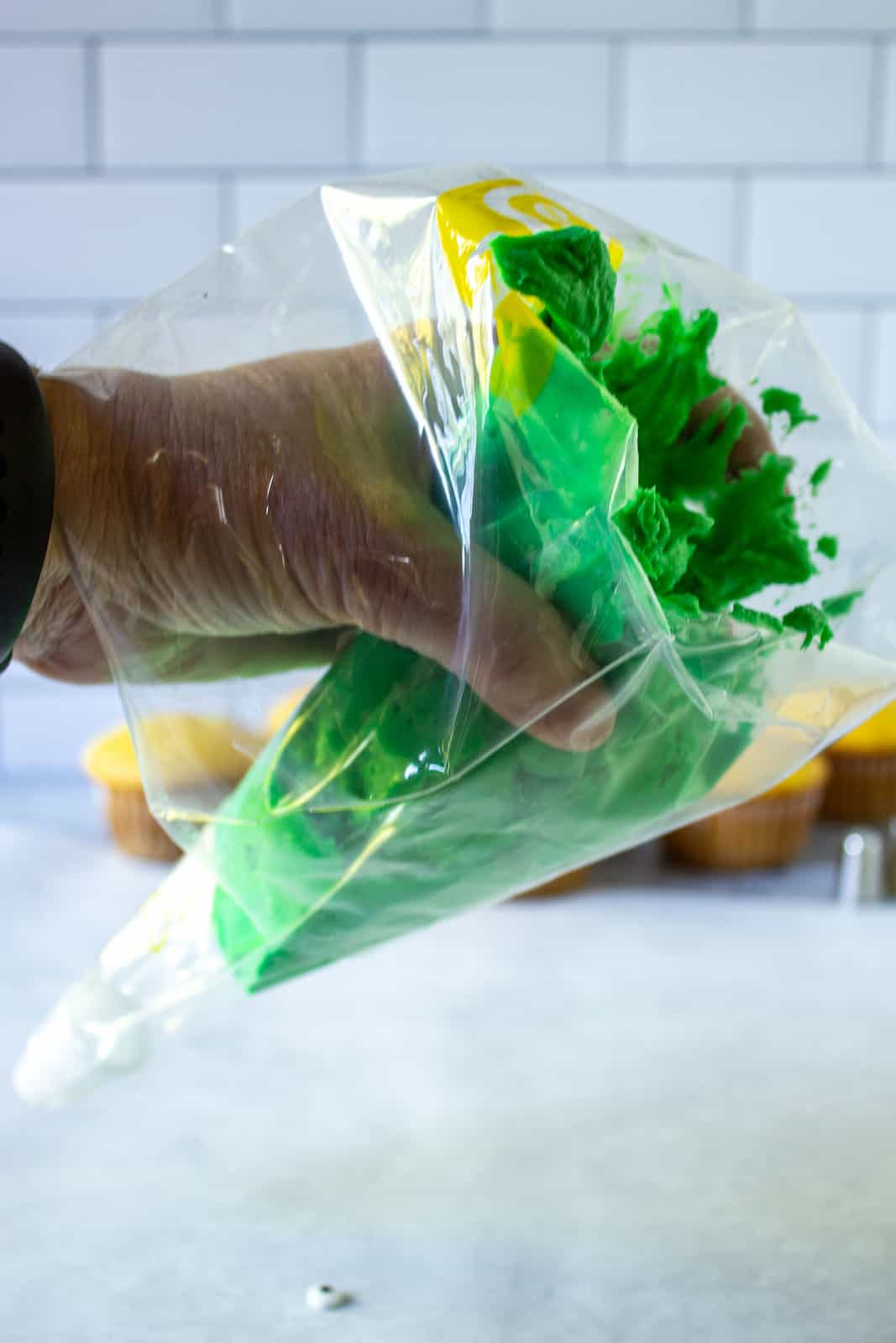 Green buttercream frosting in a plastic decorating bag.