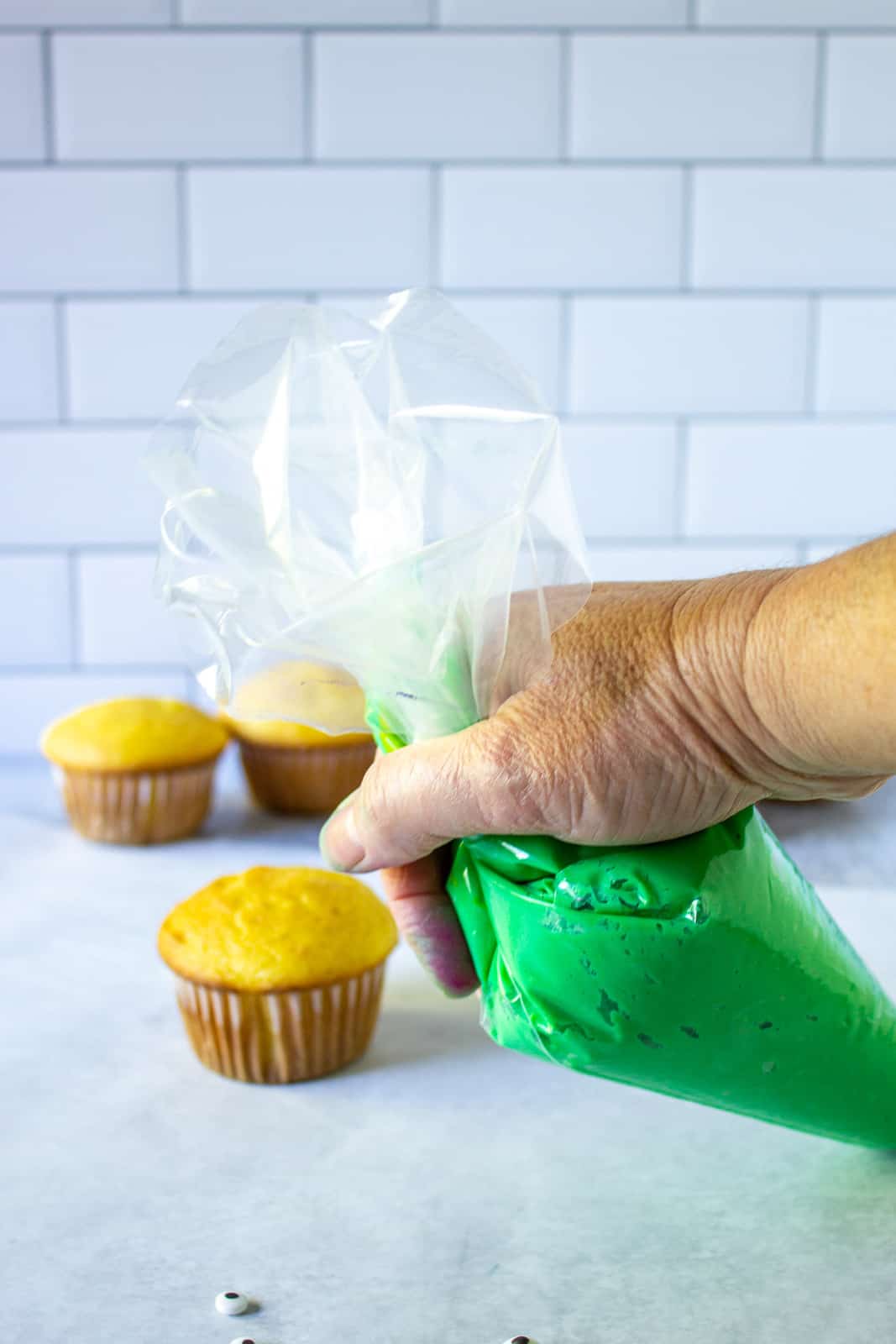 A cake decorating bag filled with green frosting. 