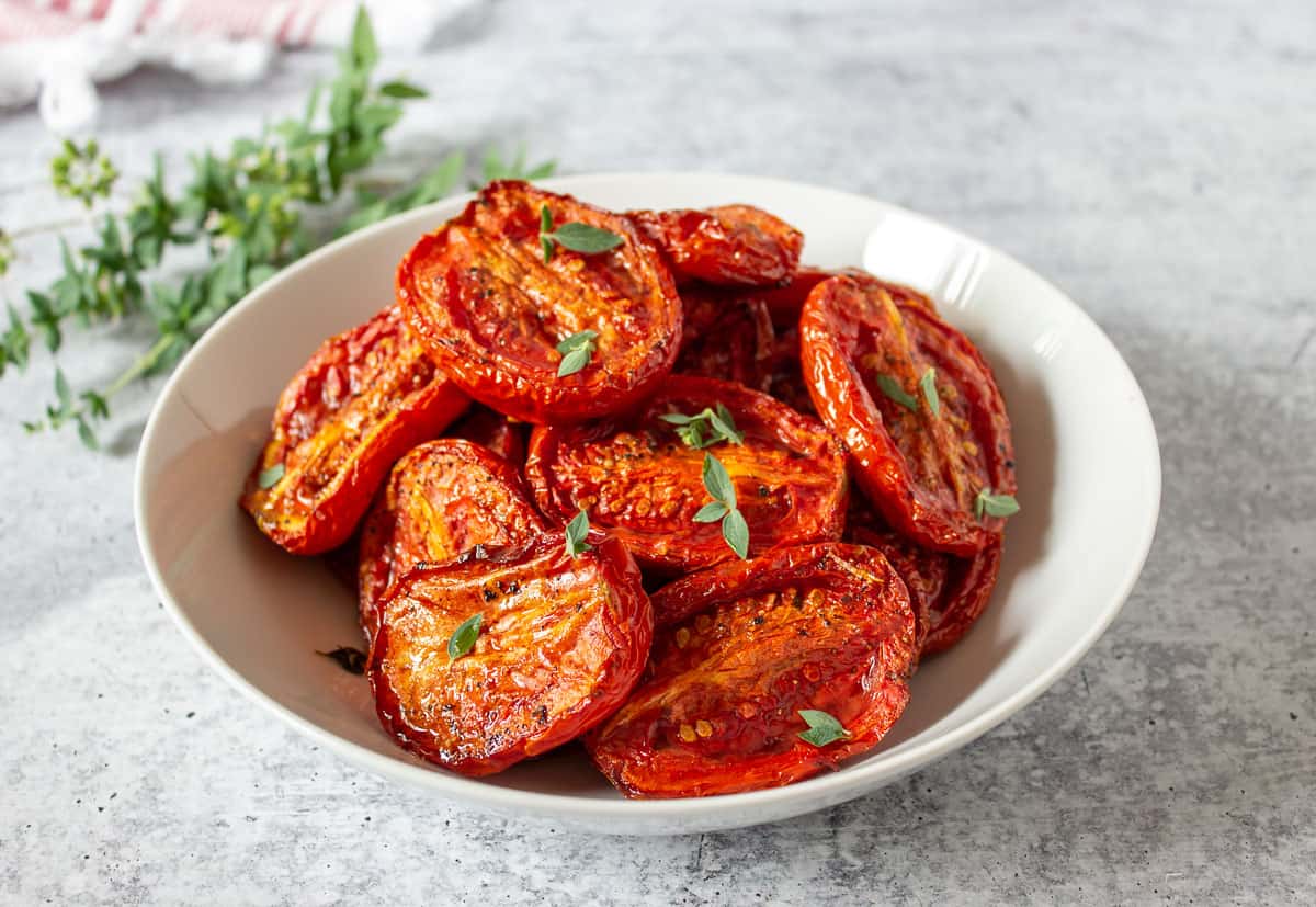 Oven roasted tomatoes in a white bowl. 